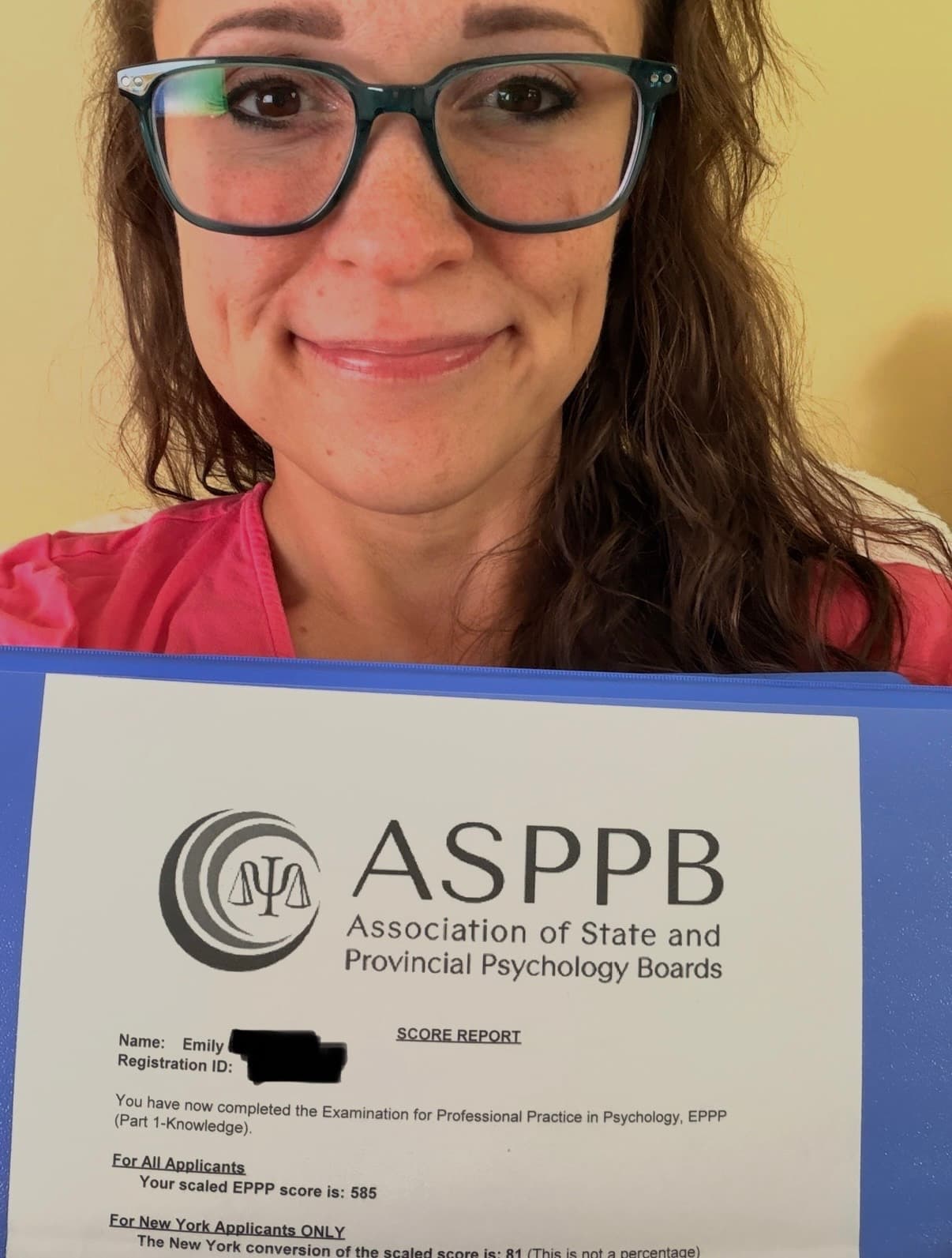 Emily holding her ASPPB score report, which reads: your scaled EPPP score is 585